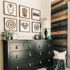 a black dresser sitting next to a wall with pictures on it