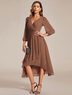 a woman is wearing a brown dress with long sleeves and a high low heme