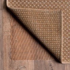 an area rug on top of a wooden floor next to a piece of wood with a brown