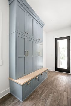 an empty room with blue cabinets and wood flooring