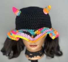 a crocheted hat with horns on top of a mannequin's head