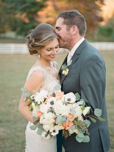 a bride and groom pose for a wedding photo in front of greenery at the botanical center