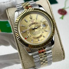 This timepiece is a Rolex Sky-Dweller, distinguished by its two-tone Oystersteel and 18ct yellow gold construction. The champagne dial features the iconic off-center 24-hour disc for dual time zone display, and an annual calendar. The watch is powered by the Calibre 9001, a complex self-winding mechanical movement. The fluted bezel, Oyster bracelet with Easylink extension, and Superlative Chronometer certification exemplify Rolex's commitment to precision and luxury. This Sky-Dweller is a sophis Classic Formal Diamond Watch With Day-date Display, Elegant Gold Watch Accessories With Date Display, Classic Gold Diamond Watch With Date Display, Luxury White Gold Watches With Date Display, Luxury Round Diamond Watch With Date Display, Luxury Yellow Gold Watch Accessories With Date Display, Gold Watch Accessories With Day-date Display For Gift, Gold Chronometer Watch Accessories With Round Dial, Timeless Gold Watch Accessories With Date Display