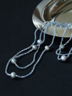 This elegant necklace features a long strand adorned with natural aquamarine and gray pearls, exuding a sophisticated charm. Perfect for adding a touch of refinement to any ensemble, it combines the serene hues of aquamarine with the timeless allure of gray pearls, creating a versatile accessory suitable for both casual and formal occasions. Metal: Recycled Sterling Silver Plated On Brass Gemstone: Aquamarine Pearl: Freshwater Pearls 9-10mm Chain Length: 1400-1450mm Weigth: 29g Elegant Light Blue Single Strand Beaded Necklace, Elegant Gray Faceted Beads Necklace, Elegant Gray Gemstone Beads Necklace, Elegant Gray Necklace With Faceted Beads, Necklaces Pearl, Gemstone Beaded Necklace, Long Beaded Necklace, Pearl Necklaces, Elegant Necklace