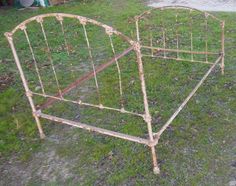 an old metal bed frame sitting in the grass