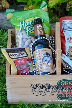 a wooden box filled with lots of different types of food and drinks on top of grass