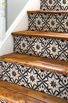 the stairs are decorated with black and white tiles on them, along with wooden handrails