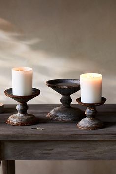 three candles sitting on top of a wooden table