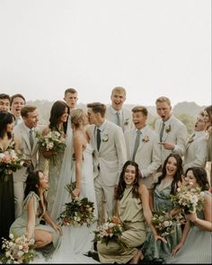 a group of people standing next to each other in front of a field with flowers