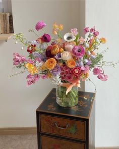 a vase filled with lots of different colored flowers