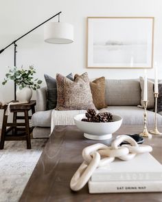 a living room filled with furniture and decor on top of a wooden table in front of a white wall