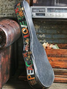 a guitar case sitting next to an old suitcase