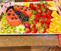 a tray filled with fruits and vegetables on top of a counter