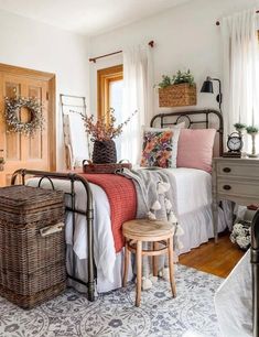 a bed room with a neatly made bed and baskets on the nightstands next to it