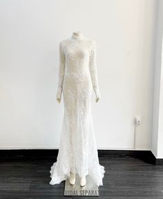 a white wedding dress on display in a room