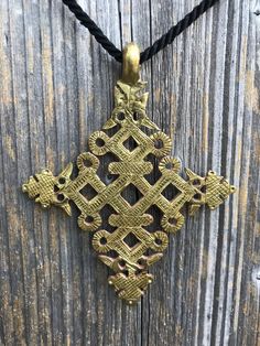 an ornate cross is hanging on a wooden wall