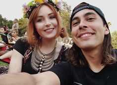 a man and woman taking a selfie at an outdoor event