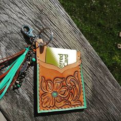 a wallet with a tassel hanging from it's side on top of a wooden table