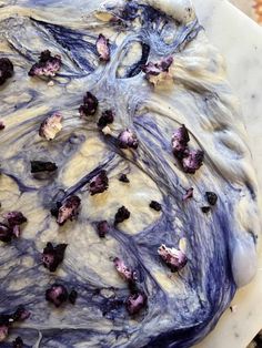 a cake with blue and white frosting sitting on top of a marble countertop