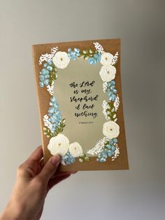 a hand holding up a card with flowers on it that says, the lord is my shepherd