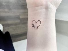 a small heart tattoo on the wrist