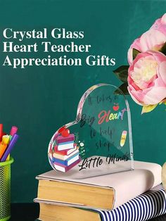 crystal heart teacher appreciation gifts on top of books with flowers and pencils next to it