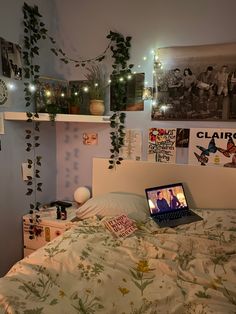 a laptop computer sitting on top of a bed in a room with plants growing up the wall