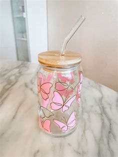 a glass jar sitting on top of a marble counter with a straw in the lid