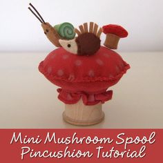 an image of a miniature mushroom spool pincusion with snail on the top