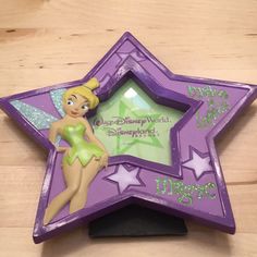 there is a purple star shaped photo frame with a tinkerbell fairy on it