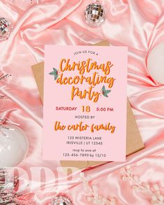 a pink christmas party card with gold foil lettering on it, surrounded by other decorations