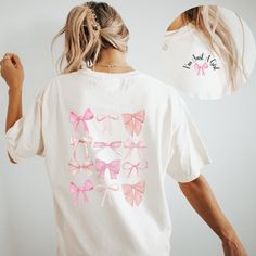 This Coquette Shirt, designed with a cute ribbon bow, serves as a girly t-shirt perfect for teens and minimalist moms, available in Comfort Colors. It's an ideal gift for your girlfriend, combining style and comfort effortlessly. 🎀𝗞𝗲𝘆 𝗗𝗲𝘁𝗮𝗶𝗹𝘀: ▪️Comfort Colors T-shirt with pocket design on front and back design on the back ▪️ Unisex fit. If you want an oversized look we recommend going up one to two sizes.  ▪️ Color options are white and ivory  ▪️Glass cup comes with the bamboo lid an Pink Tops With Ribbon For Spring, Cute Cotton Tops With Pink Bow, Trendy White Top With Bow, Pink Ribbon Tops For Spring, Cute White Top With Bow, White Cotton Top With Pink Bow, Cute Cotton Top With Pink Bow, Cute White Top With Pink Bow, Cute White Top With Bow Detail