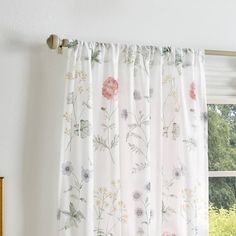 a window with floral curtains hanging in front of it