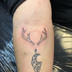 a tattoo on the arm of a person with deer antlers and an ornament