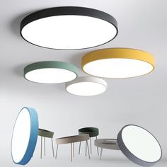 several circular lights hanging from the ceiling in different colors and sizes, with tables below them