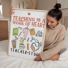 a woman sitting on a bed holding up a sign that says teaching is a work of heart