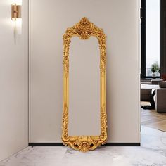 an ornate gold framed mirror against a white wall