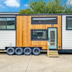 a tiny house on wheels is parked in a lot