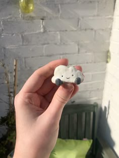 a hand holding a small toy with a cloud on it