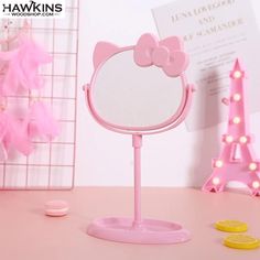 a pink hello kitty makeup mirror on a table