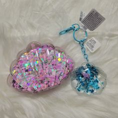 there are two bags of plastic beads on the white furnishing, one has a blue and pink bead in it