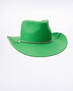 The Green Cowboy Hat is inspired by the deep mystical wetlands and singing choirs from the bottomless forest. The unisex hat is shaped similarly to the classic cowboy hat with a dynamic brim. It comes with a metal chunky chain and a cream white pearl that symbolises the magical force of the Scandinavian moon light. Western Green Hat Band For Festivals, Western Green Hat Bands For Festival, Green Western Style Hat Band For Festivals, Green Flat Brim Hat For Country Events, Adjustable Green Fedora For Country Events, Green Short Brim Hat For Country Events, Green Fedora For Country Events, Green Brimmed Felt Hat For Festival, Green Fedora Hat For Rodeo