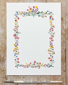 a watercolor painting of flowers in a square frame on white paper with a pencil