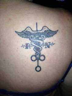 a woman's back with a medical symbol tattoo on her left side ribcage