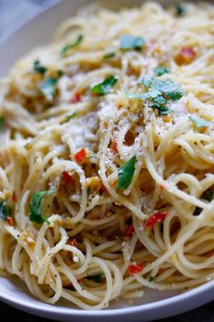 a white plate topped with pasta and sauce covered in parmesan sprinkles