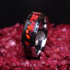 "This is the Lava Rock Ring, primarily made with Ruby, Crimson Red and Lava Rock Opal on a black and red background and glows red. The primary color of the Lava Rock Opal is purple/black with constantly shifting colors and hues which include hints of red. This contrasts nicely with the Crimson Red Opal. The crushed Ruby provides depth to the ring. *Note* Red is the dimmest glow and especially the black pigment makes the glow very dim. A UV light charges the red background well but in order to pr Round Tungsten Carbide Jewelry Gift, Red Inlay Rings For Gifts, Glow In The Dark Wedding, Rock Ring, Mens Black Ring, Wedding Band For Men, Rock Rings, Red Opal, Dark Wedding