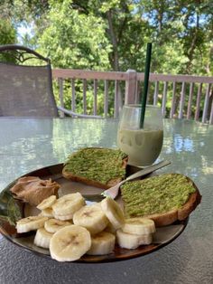 a plate topped with sliced bananas and avocado next to a glass of milk