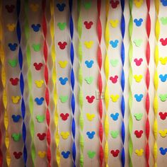 mickey mouse party streamers are lined up on the wall in front of a window