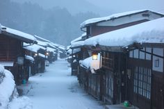 a row of wooden buildings covered in snow