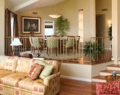 a living room filled with furniture next to a stair case in front of a window